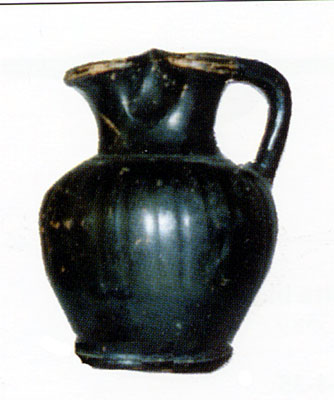 <i>Oinochoe</i> a vernice nera alta 9 cm e mezzo. Reperto della tomba 1. (dal volume GIOVANNA PACILIO - GIUSEPPE COMPAGN