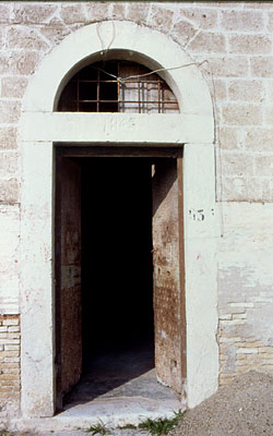 Ingresso laterale di destra della facciata che porta incisa sull'architrave la data del 1865. (foto Gioacchino Albanese)