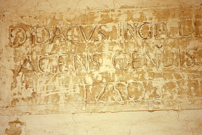 Epigrafe della lapide murata al di sopra di uno degli ingressi del loggiato. Essa riferisce di restauri al palazzo nel 1