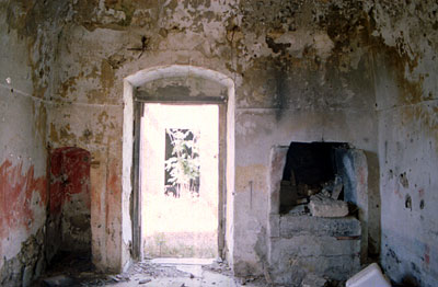 Interno di una delle camere poste ai lati dell'ingresso del cortile. Si tratta di stanze modeste, dotate però di camino.